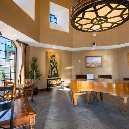 The Grand Hotel At The Grand Canyon Tusayan Εξωτερικό φωτογραφία The photo depicts a stylish interior space, likely a living room or lounge area. Key features include:

- A grand piano made of polished wood, centrally located.
- High ceilings with a large, decorative light fixture that resembles a wheel.
- Large w