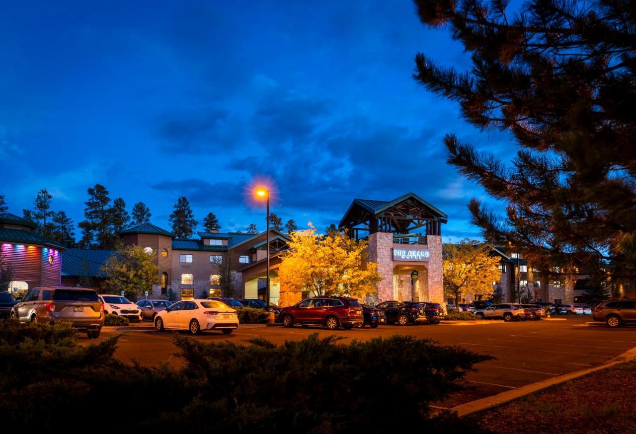 The Grand Hotel At The Grand Canyon Tusayan Εξωτερικό φωτογραφία The photo shows a hotel or lodge building during twilight, with a blue sky and clouds. There are several cars parked in front, and some illuminated trees add warmth to the scene. The architecture features a combination of stone and wood elements, and