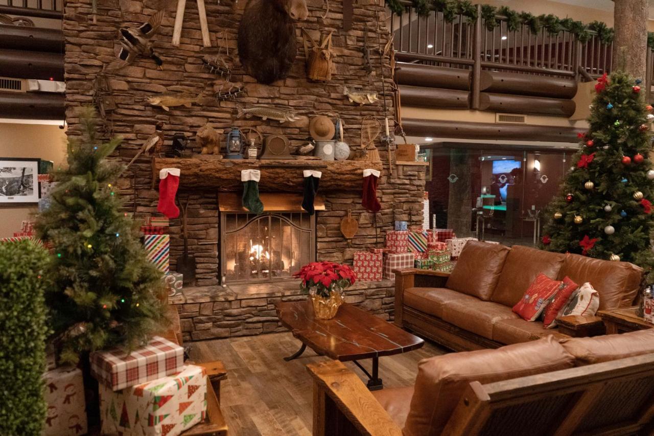 The Grand Hotel At The Grand Canyon Tusayan Εξωτερικό φωτογραφία The photo depicts a cozy interior setting, likely a lodge or cabin, decorated for the holiday season. In the center, there is a stone fireplace with a roaring fire, adorned with festive stockings hanging from the mantel. Above the fireplace, there ar